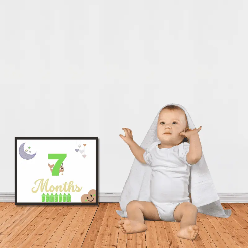7 month old baby with a framed milestone card